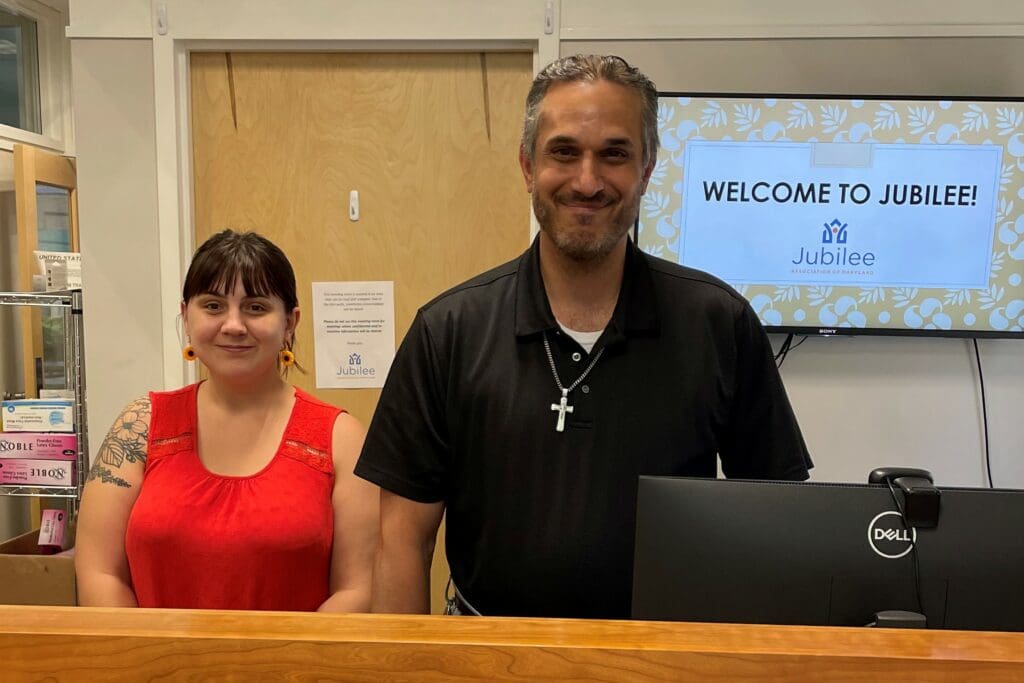 man and woman standing at reception desk