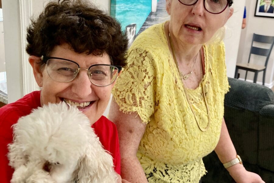 Two women together with their small dog