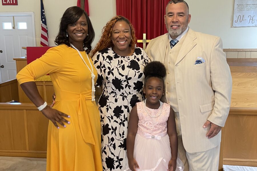 Family portrait inside a church: Left to right Elsie Rose, Britni Rose, Allen Rose, standing in front young daughter.