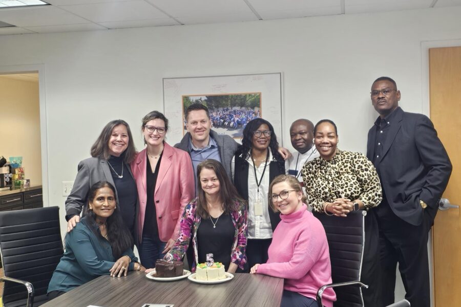 A group of people around a table with cake