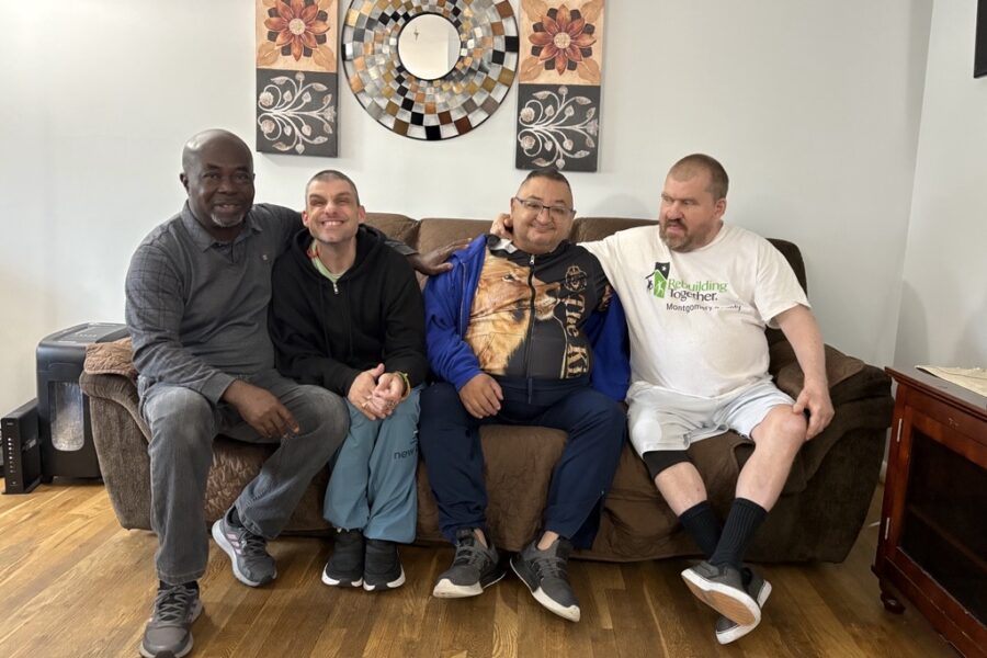 Four men sit together on a sofa