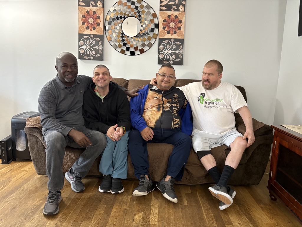 Four men sit together on a sofa