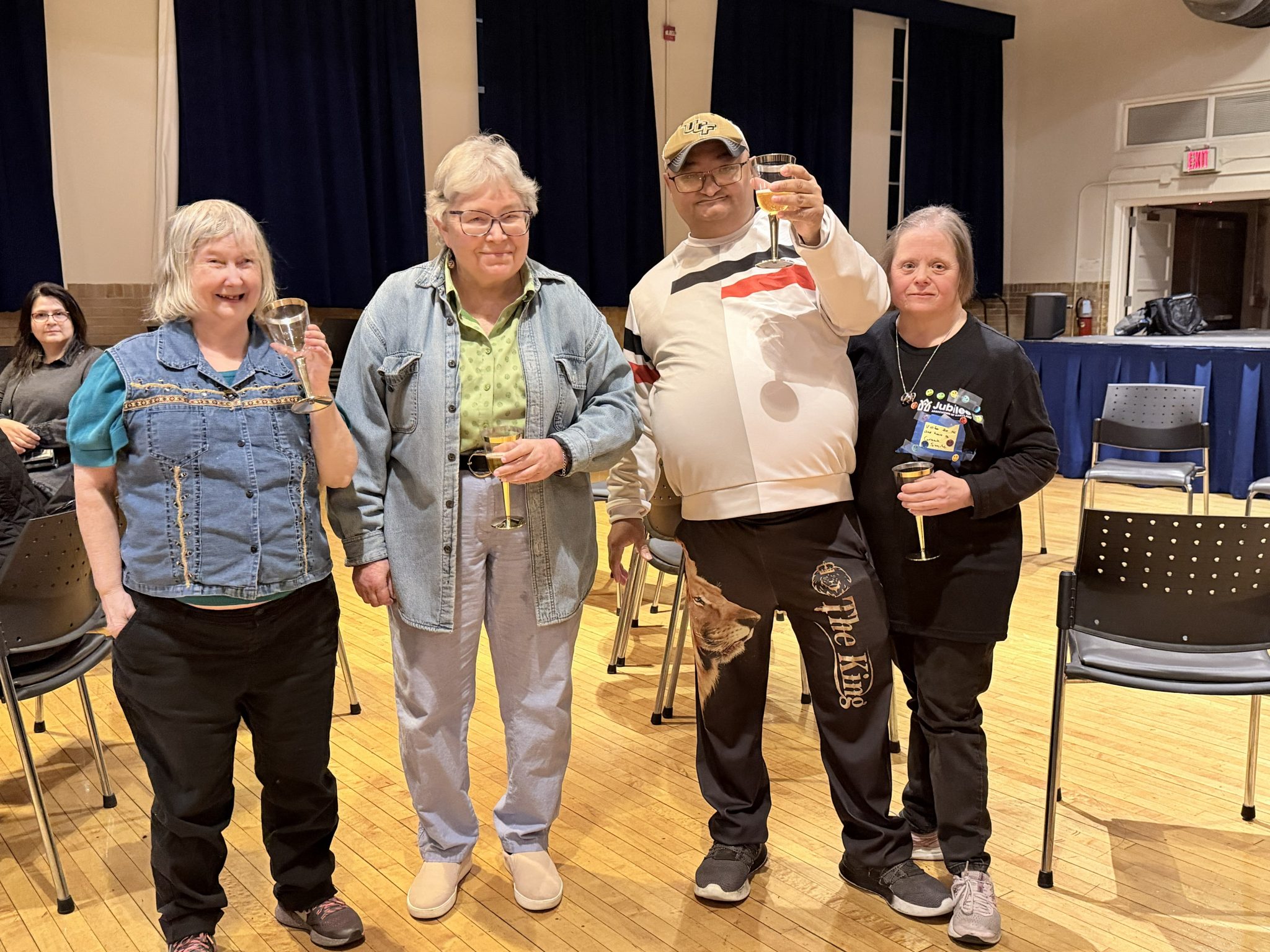 Four people stand together in a town hall.