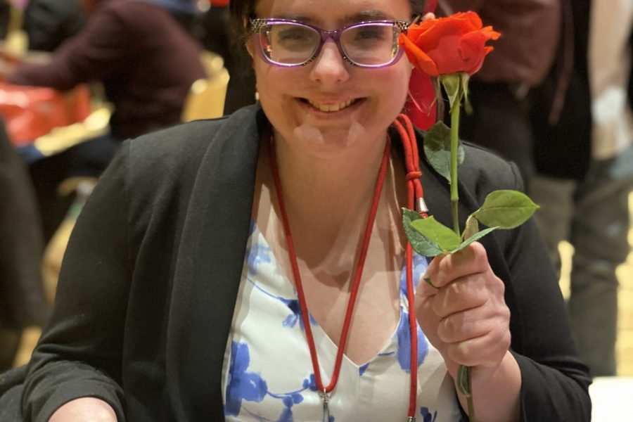 A young woman holds up a red rose [Kitty at Valentine's Day party]