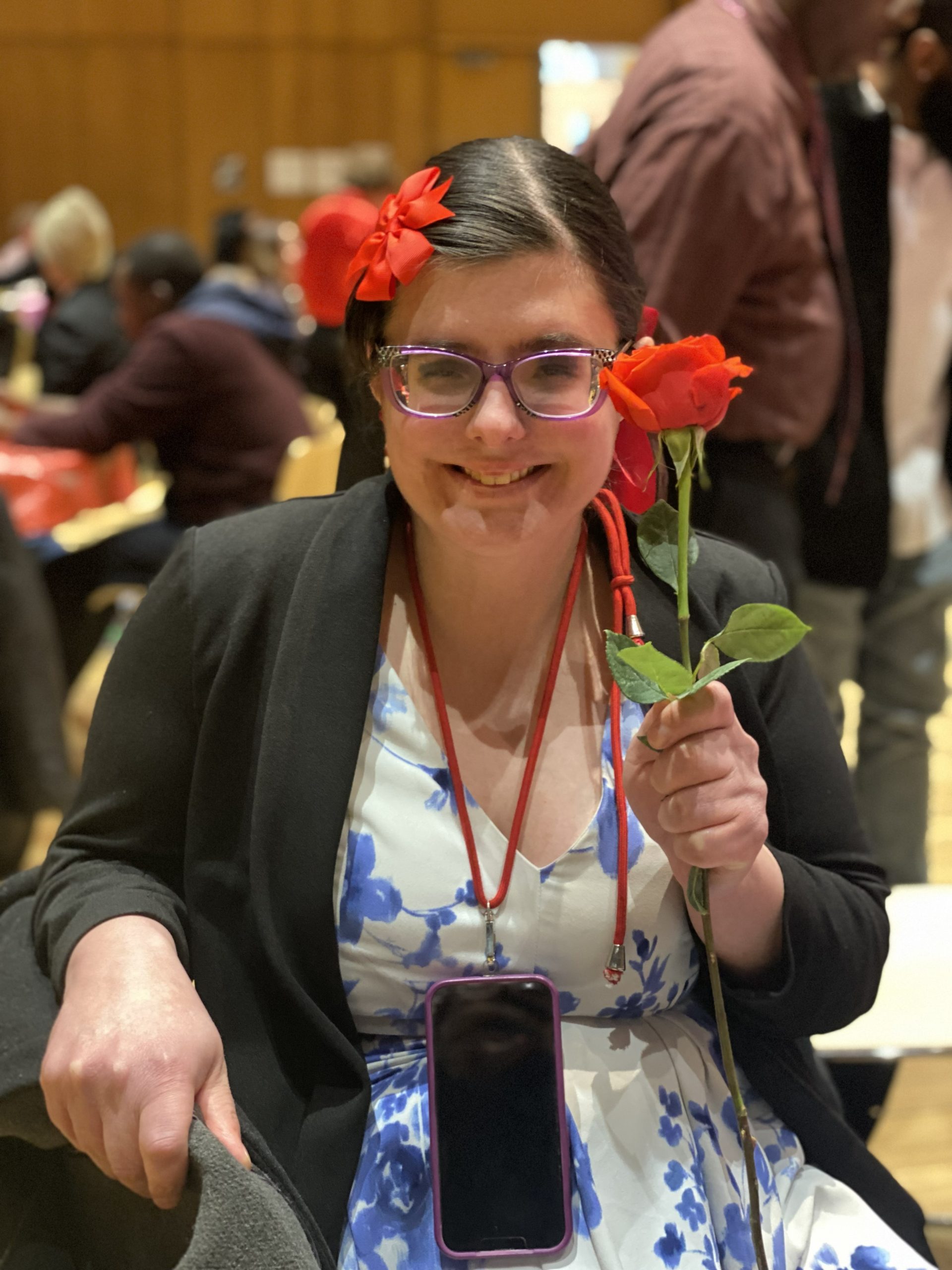 A young woman holds up a red rose [Kitty at Valentine's Day party]